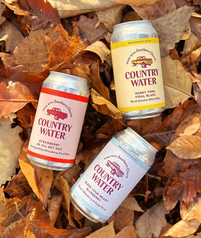 Cans of Country Water on a pile of autumn leaves