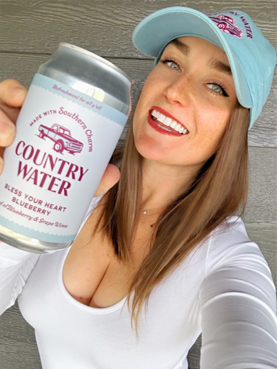 Tana holding a can of blueberry country water
